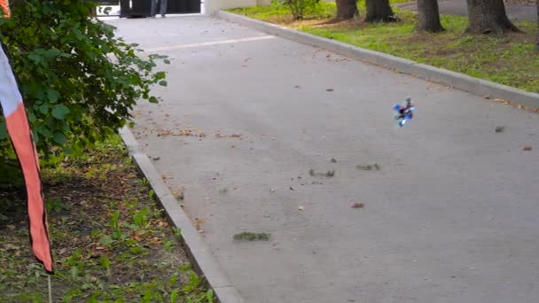 Повільний рух ручної роботи поліцейського, що літає в парку під час перегонів безпілотниками — стокове відео