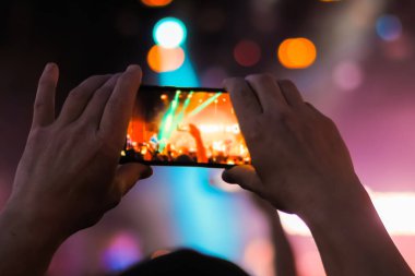 Adam akıllı telefonlu canlı müzik konseri videosu kaydediyor.