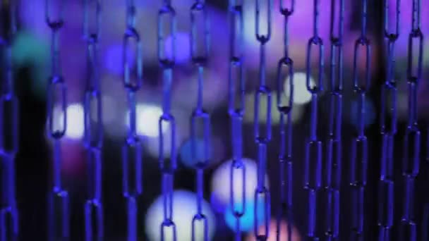 Синяя металлическая цепь раскачивается на красочном фоне боке - крупным планом — стоковое видео