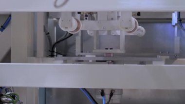 Otomatik seçim ve yerleştirme robotik kol manipülatörü boş plastik bardakları taşır
