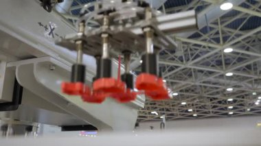 Otomatik robot kol manipülatörü kırmızı plastik çerez kesicileri hareket ettirir