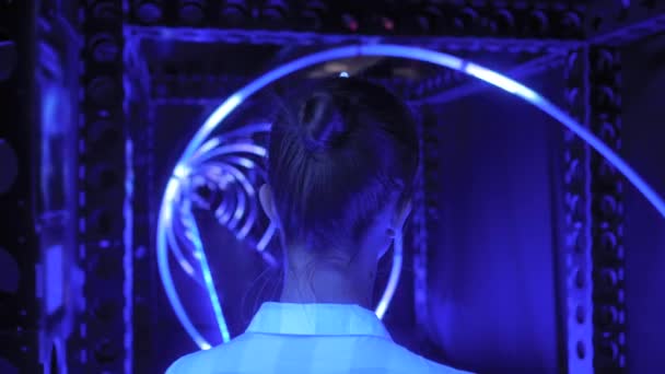 Back view of young woman looking around at interactive futuristic exhibition — Stock Video