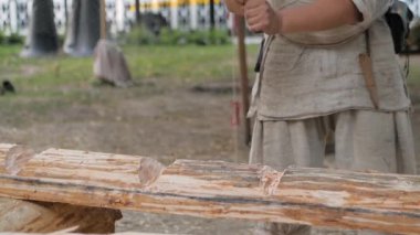 Ortalama festivalde oduncu büyük kütükleri baltayla kesiyor. Yavaş çekim.