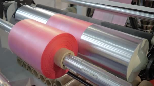 Automatyczna maszyna do produkcji toreb plastikowych: ruchomy wałek z różową folią na wystawie — Wideo stockowe