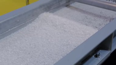 Otomatik şist karıştırıcıda geri dönüştürülmüş plastik granüller, fabrikada taşıma bandı.