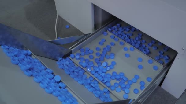 Nombreux bouchons de bouteilles en plastique bleu se déplaçant sur bande transporteuse - ligne de production — Video