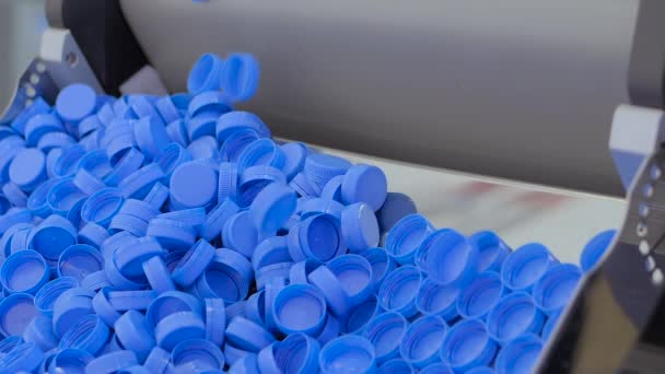 Lassú mozgás: a szállítószalagról lehulló kék műanyag kupakok — Stock videók