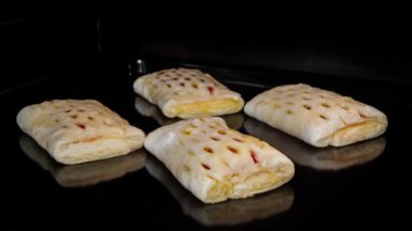 Zaman ayarlı - dört ev yapımı çörek ve elektrikli fırında kırmızı çilek reçeli.