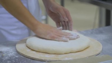 Fırıncının elleri fırında taze hamur yoğuruyor. Kapatın.