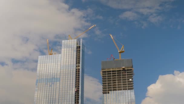 Zeitraffer beweglicher gelber Turmdrehkräne und unvollendeter Hochbau — Stockvideo