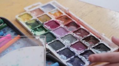 Boya-box, suluboya fırça paleti boyar.