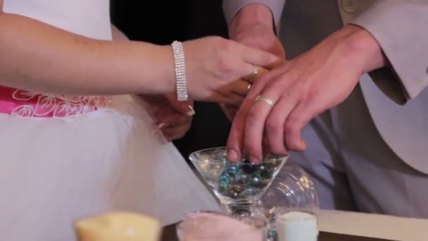 Cerimônia de areia sendo realizada no casamento. Mãos de noiva segurando vaso com areia colorida durante a festa de casamento — Vídeo de Stock