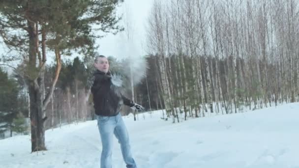 冬の森、スローモーションで雪で雪だるまを持っているカップルの戦い — ストック動画