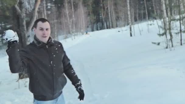 Par med snöboll kampen i snön i vinter skog — Stockvideo