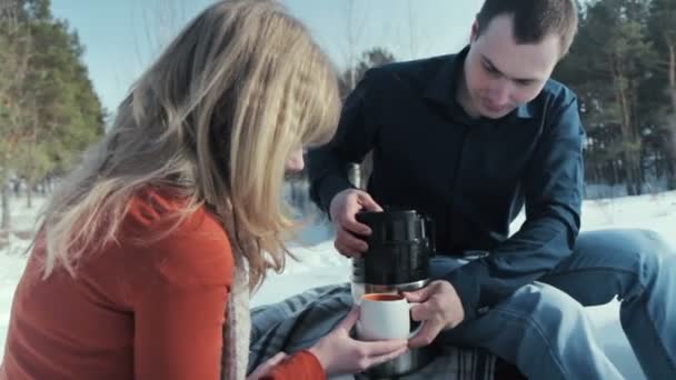 Jeune paire en bois. L'homme verse le thé d'un thermos . — Video