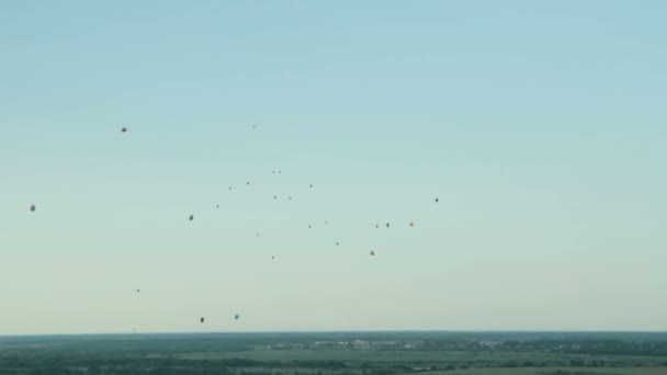 Повітряні кулі летять у блакитному небі — стокове відео