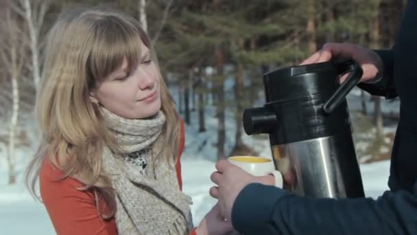 Junges Paar aus Holz. Mann gießt Tee aus Thermoskanne. — Stockvideo