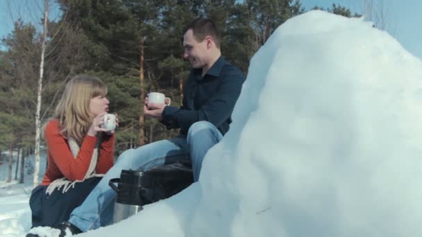 Νεαρό ζευγάρι στην αγάπη σε χειμερινές διακοπές απολαμβάνοντας τη φύση και πίνοντας ζεστό τσάι — Αρχείο Βίντεο