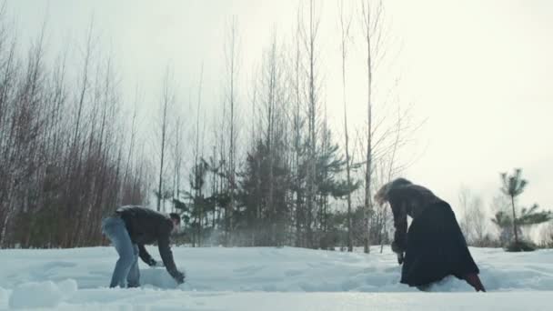 Ungt par spela utomhus i snön, slowmotion — Stockvideo