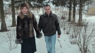 Kış parkta yürüyen genç mutlu çift