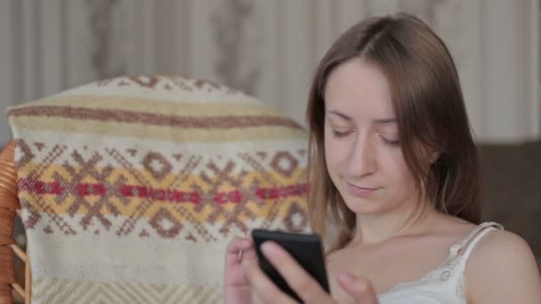 Jeune belle femme assise avec téléphone intelligent . — Video