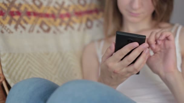 Jeune belle femme assise avec téléphone intelligent . — Video