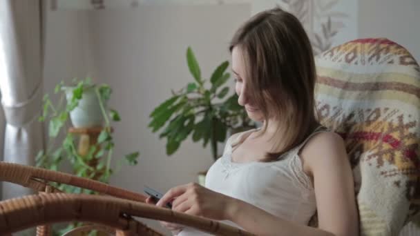 Jeune belle femme assise avec téléphone intelligent . — Video