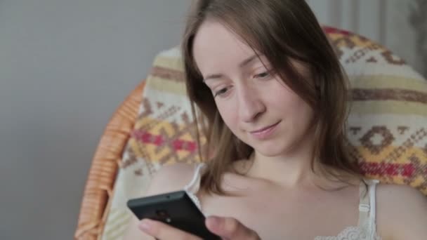 Jeune belle femme assise avec téléphone intelligent . — Video