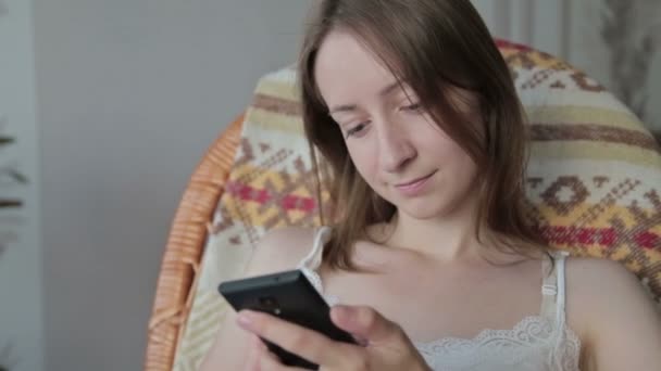 Jeune belle femme assise avec téléphone intelligent . — Video