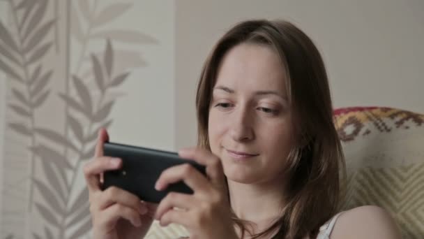 Jeune belle femme assise avec téléphone intelligent . — Video