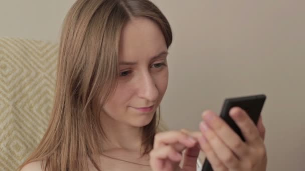 Jeune belle femme assise avec téléphone intelligent . — Video