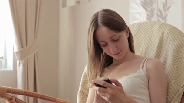 Jovem bela mulher sentada com telefone inteligente . — Vídeo de Stock