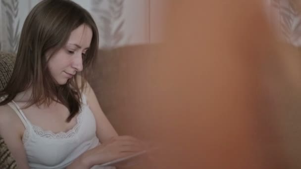 Jeune femme lisant un livre sur le canapé — Video