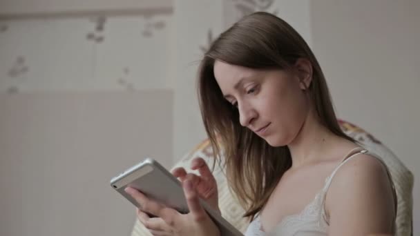 Mulher em casa relaxante em balancim, poltrona e usando tablet — Vídeo de Stock