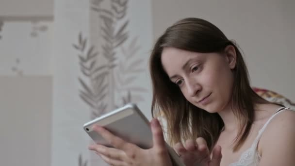 Vrouw aan het huis ontspannen in rocker, leunstoel en gebruiken tablet — Stockvideo