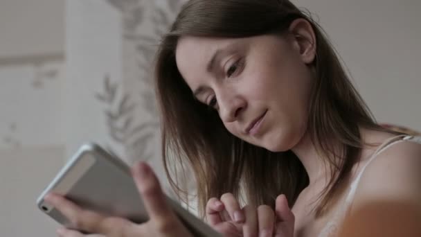 Woman at home relaxing in rocker, armchair and using tablet — Stock Video