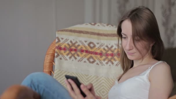 Tânăra femeie frumoasă care stă cu telefonul inteligent . — Videoclip de stoc