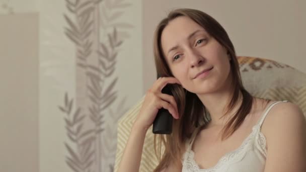 Girl on armchair, rocker with remote control — Stock Video