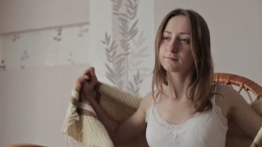 Genç kadın uzaktan kumanda tutarak ve evde tv izlerken battaniye ile örtülü