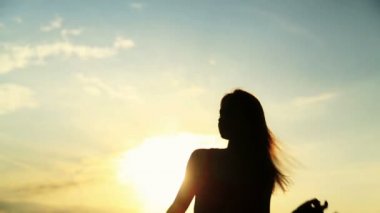 Güzel gün batımı sırasında dans kadın silüeti. Doğal ışık ve karanlık.