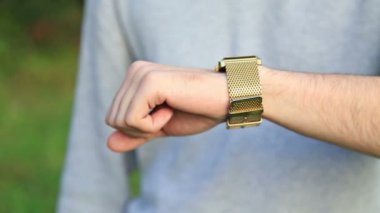 Adam onun kol saati zamanında kontrol