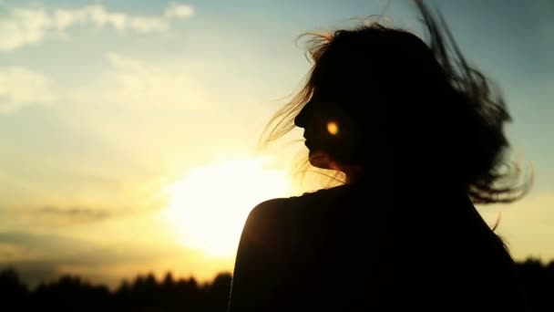 Una silhouette di una donna su un tramonto gira la testa — Video Stock