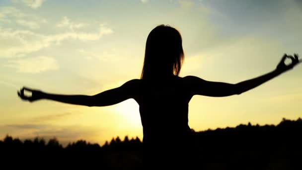 Silhouette de la femme dansant pendant un beau coucher de soleil. Lumière naturelle et ténèbres . — Video