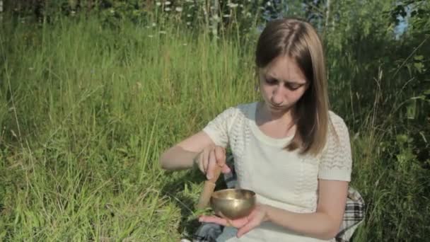 Young beautiful lady relaxing with nepal singing bowl — Stock Video