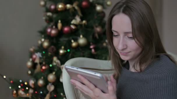 Donna felice guardando in tablet PC davanti all'albero di Natale — Video Stock