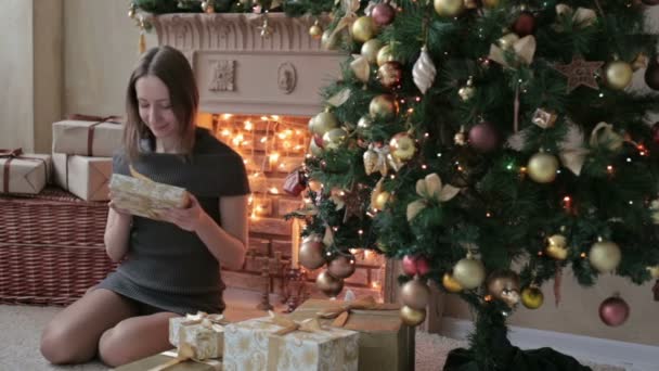 礼物在圣诞树前的年轻女子 — 图库视频影像