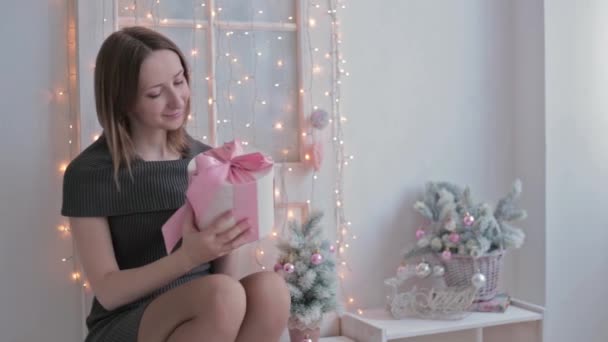 Boldog fiatal nő karácsonyi jelen dobozának kinyitása — Stock videók