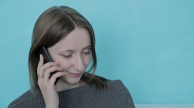 Genç kadın kanepede rahatlatıcı cep telefonu üzerinde arkadaşlar sohbet