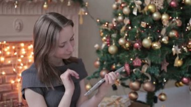 tablet pc Noel ağacı önünde bakarak mutlu bir kadın