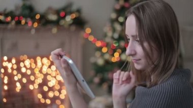 tablet pc Noel ağacı önünde bakarak mutlu bir kadın